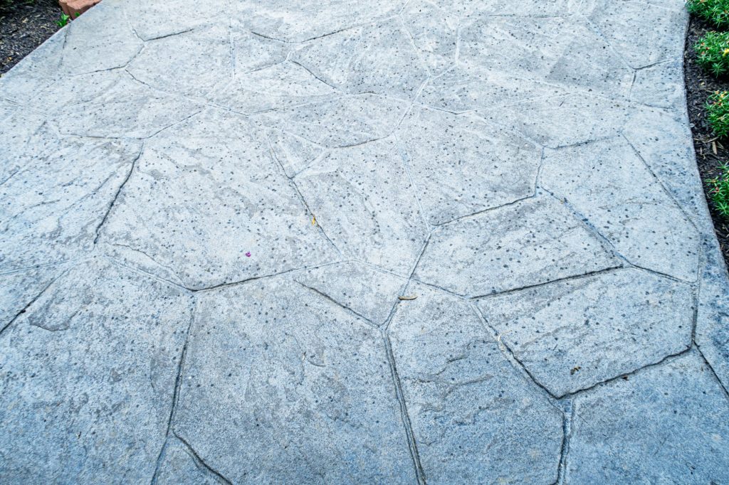 First rain drops hitting a stamped concrete walkway
