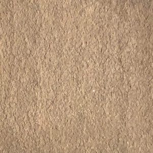 Smooth beige stone wall coping topping a brick wall with mortar joints, designed to protect and finish the wall edge.